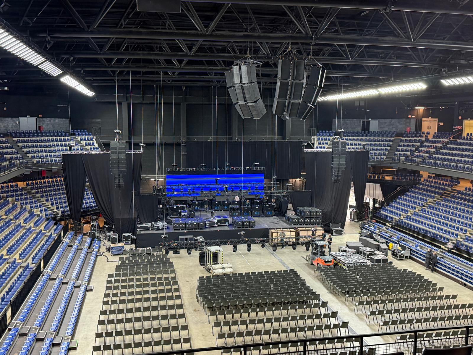 Podium- en geluidsopbouw in een arena voor publiek arriveert
