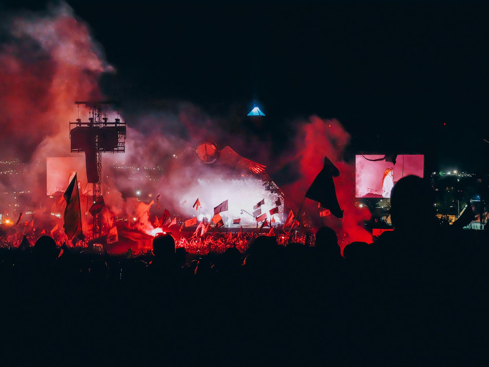 Festivalpodium 's nachts met rook en vlaggen in het publiek